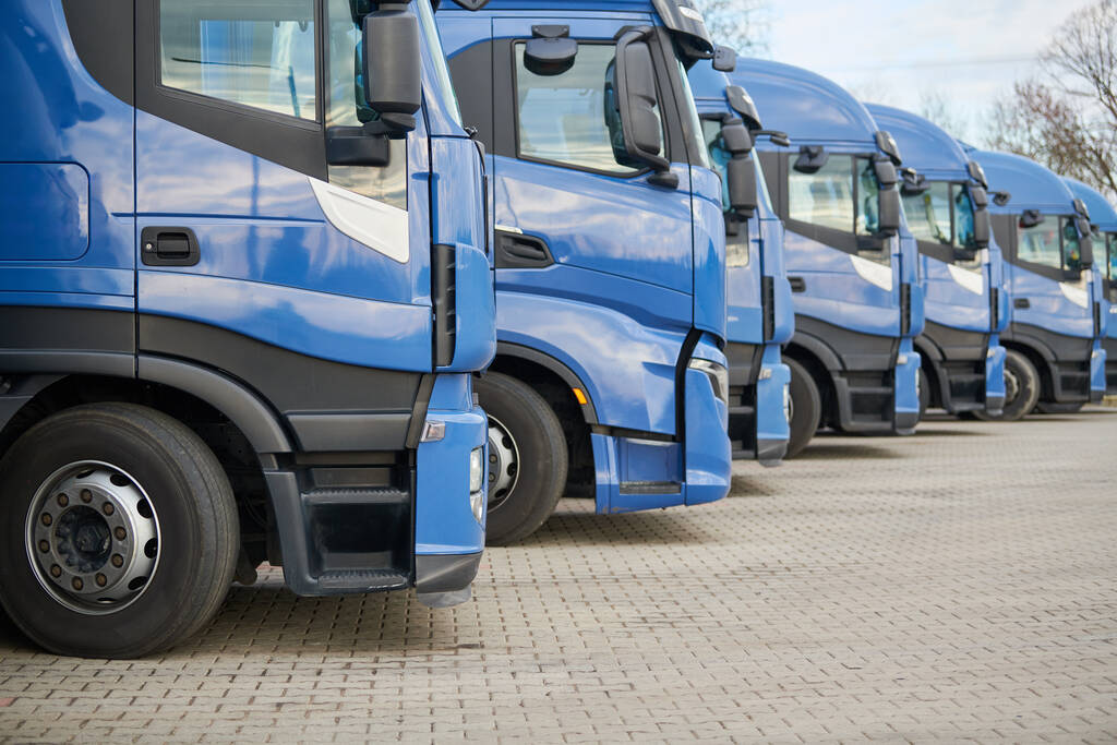 Logistics transportation service company. Fleet of commercial delivery lorry trucks in row. Freight and shipping concept